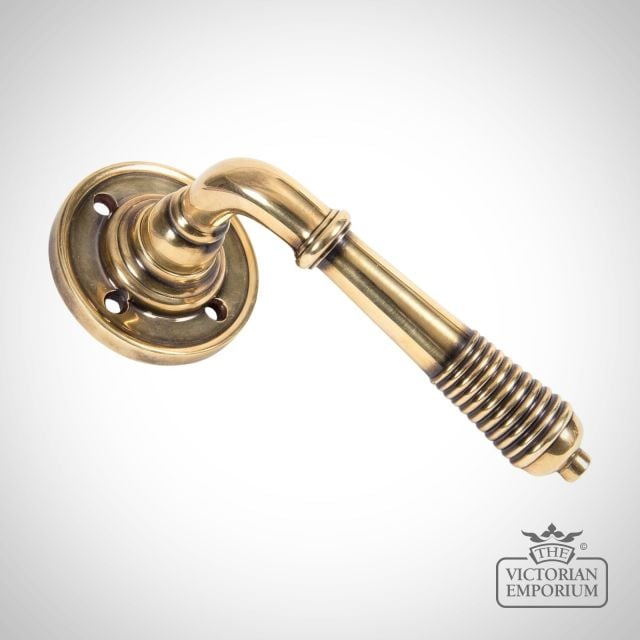 Reeded Lever Handle on Rose in Aged Brass