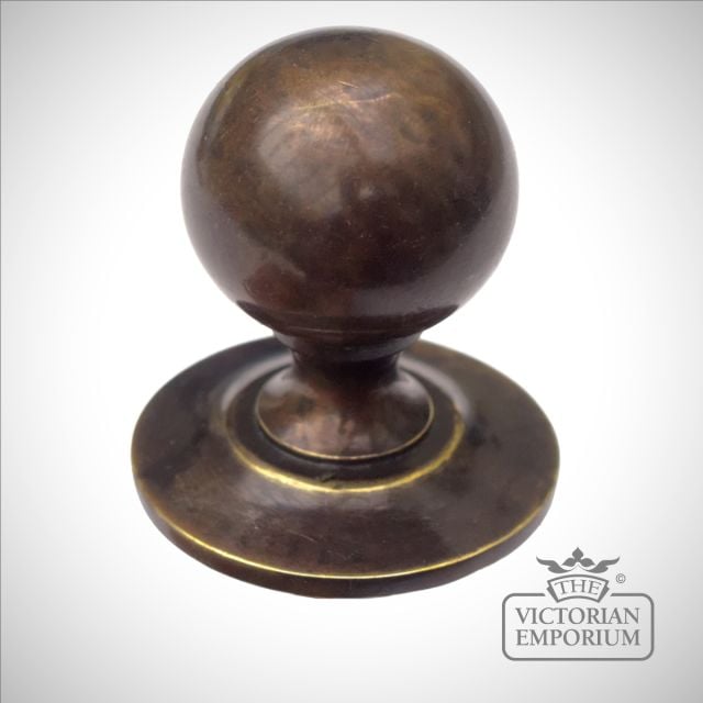 Round cabinet knob in antique brass
